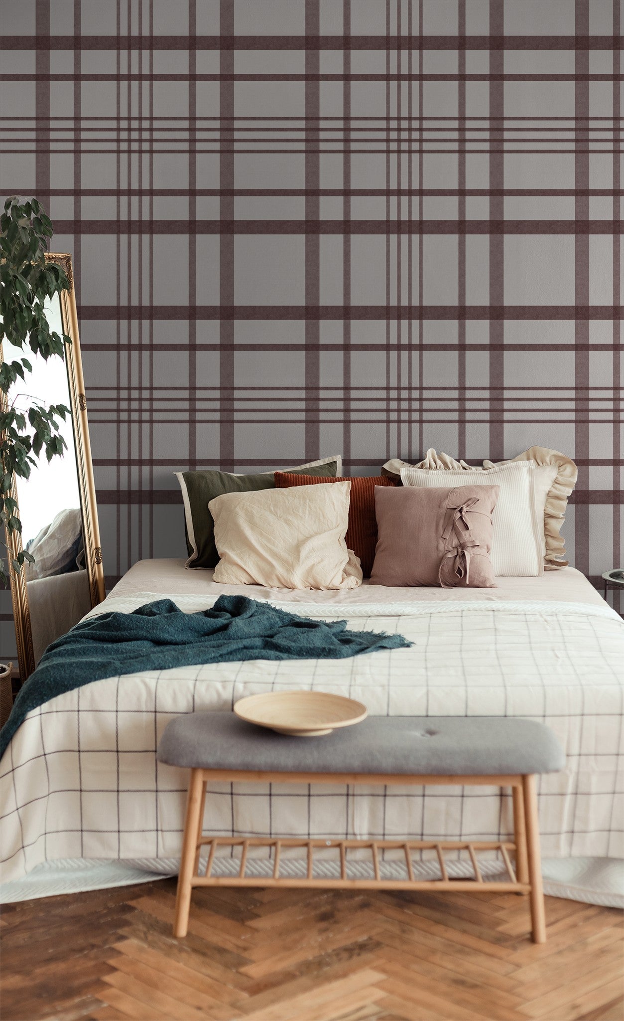 Maroon plaid wallpaper in cozy bedroom with pillows and mirror.
