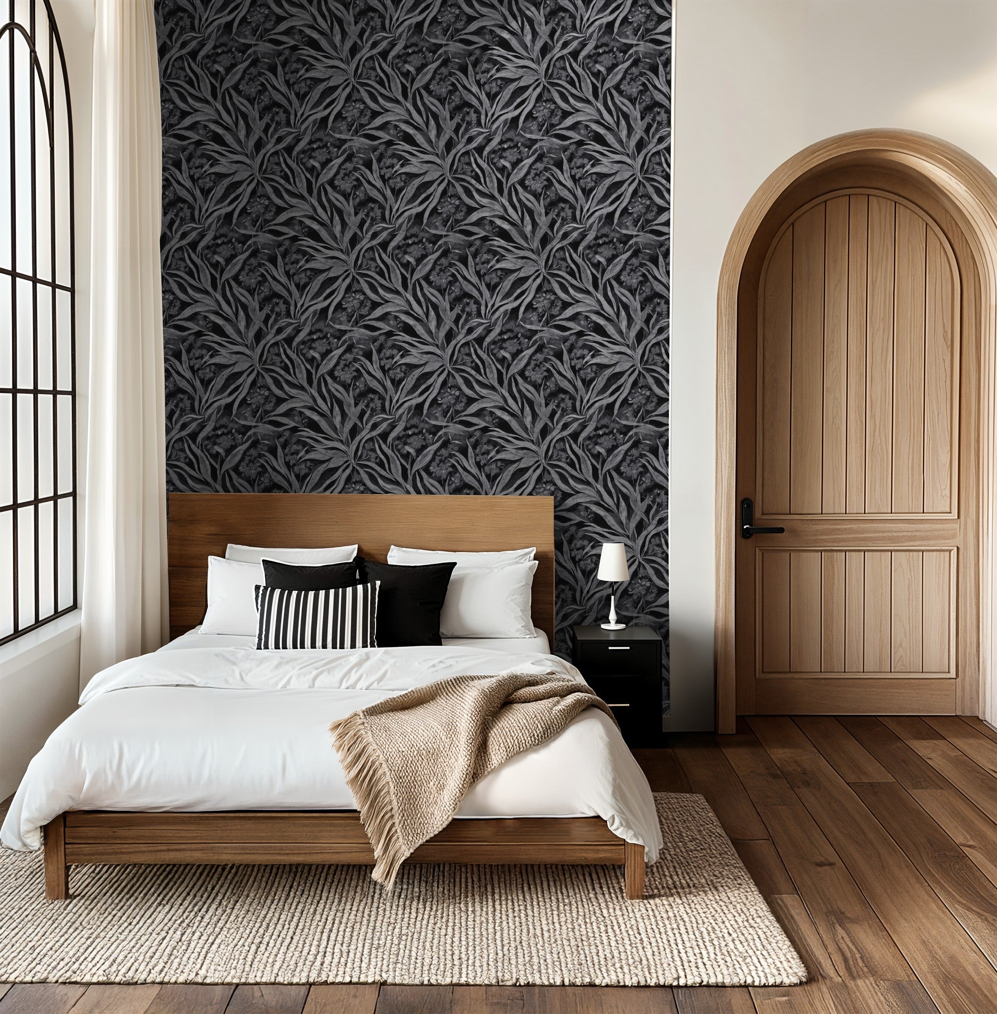 Monochrome foliage wallpaper in elegant bedroom with wooden bed and arched door.