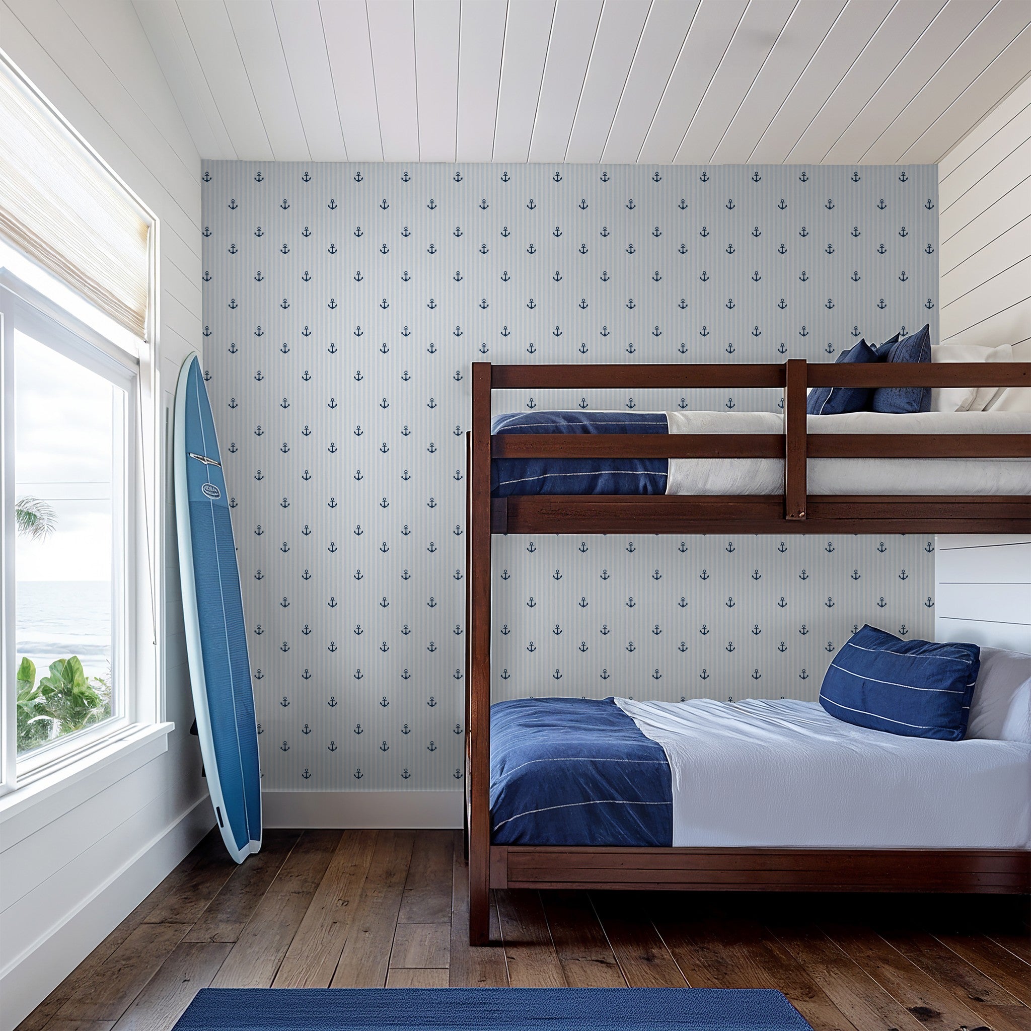 Nautical blue anchor wallpaper in coastal-themed bedroom with bunk beds.
