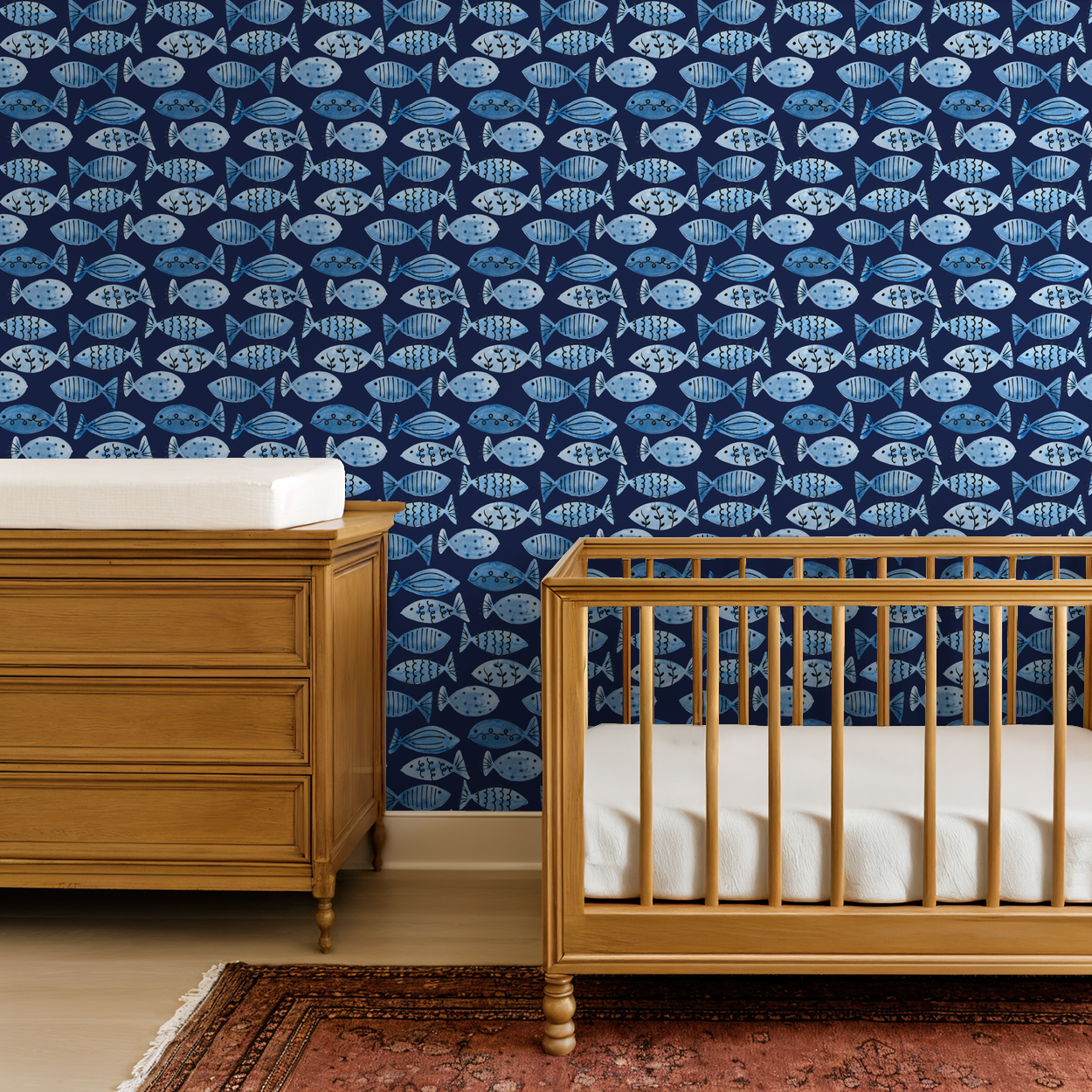 Navy blue fish patterned wallpaper in a child's room with wooden crib and dresser.