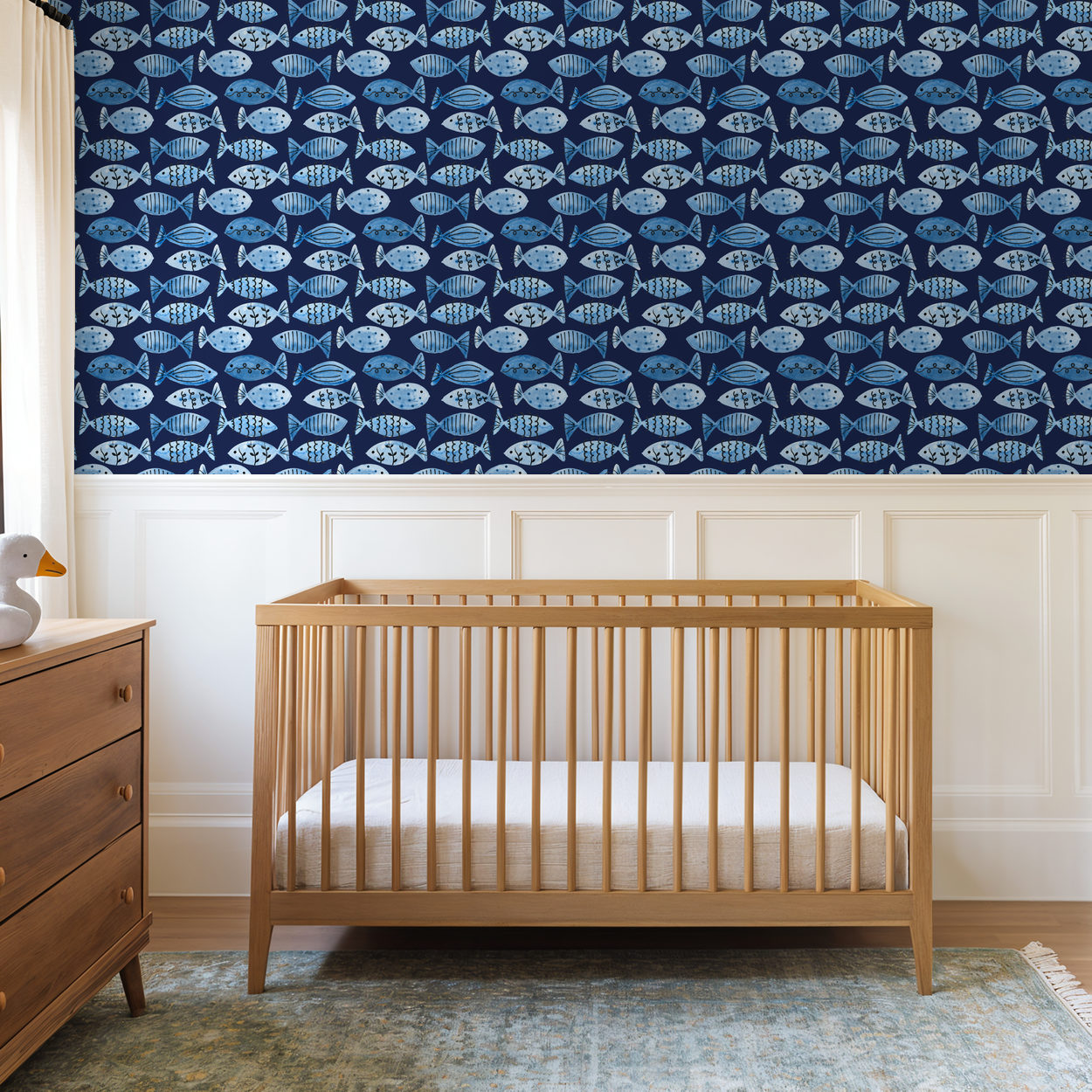 Navy blue fish pattern wallpaper in a child's nursery with wooden crib.