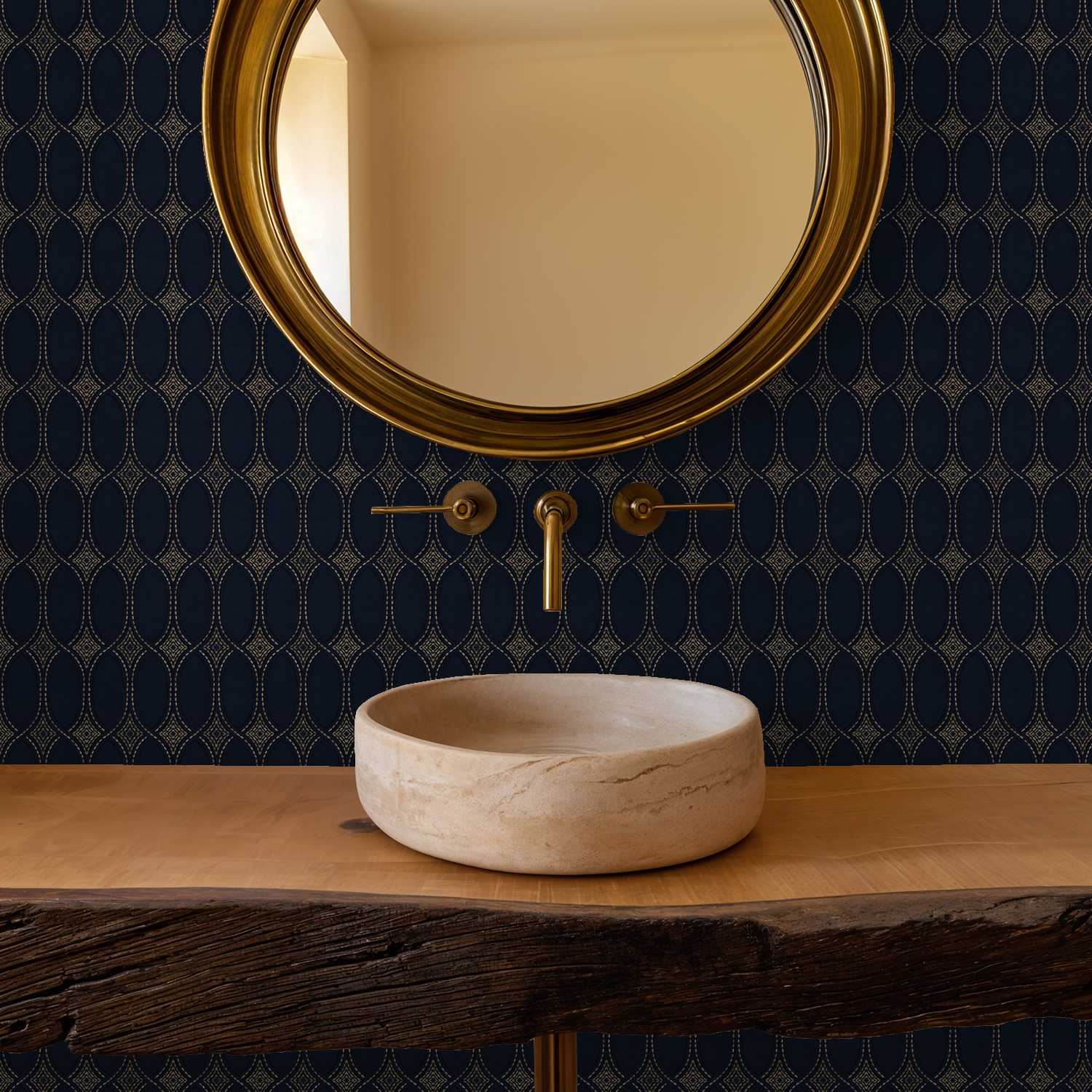 Navy and gold geometric wallpaper in bathroom with round mirror and stone sink.