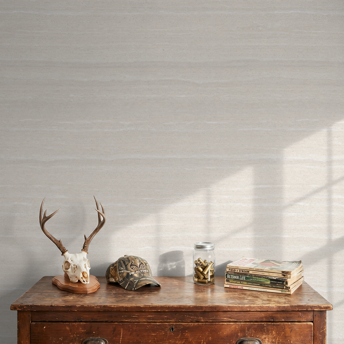 Neutral textured wallpaper in a rustic setting with antlers and decor.
