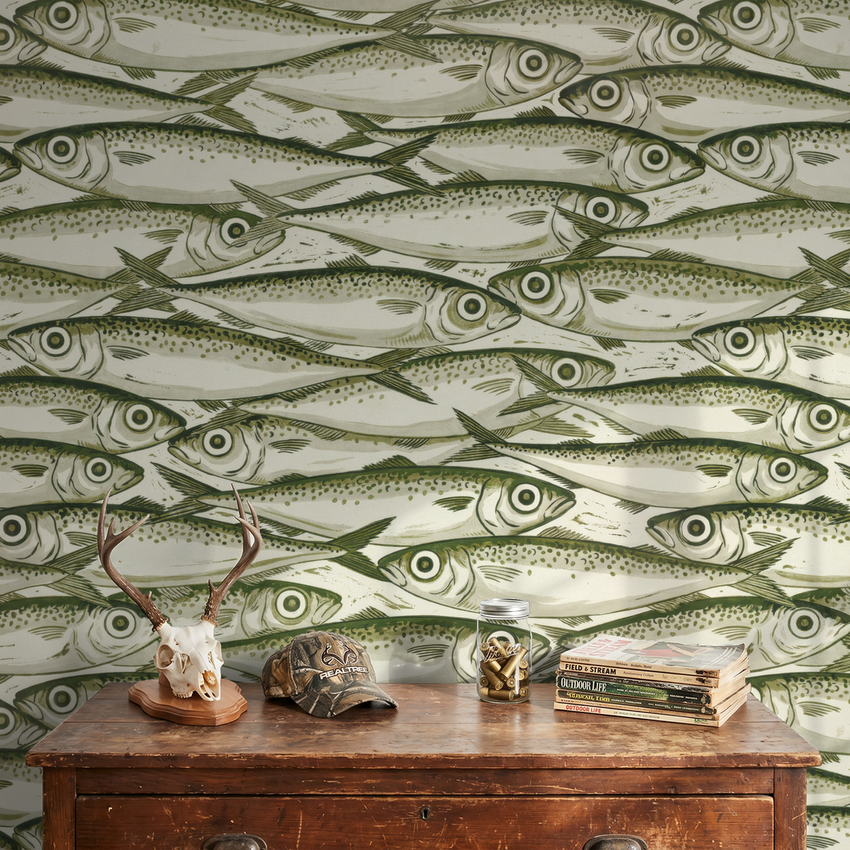 Olive and cream fish pattern wallpaper in rustic room with antler decor.
