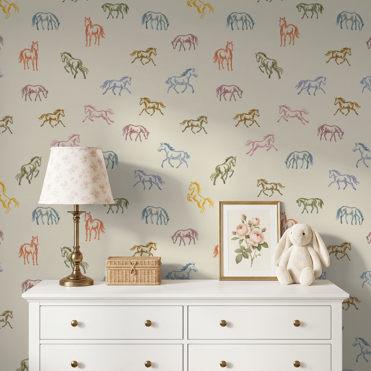 Whimsical pastel horse wallpaper in a nursery with a white dresser and lamp.