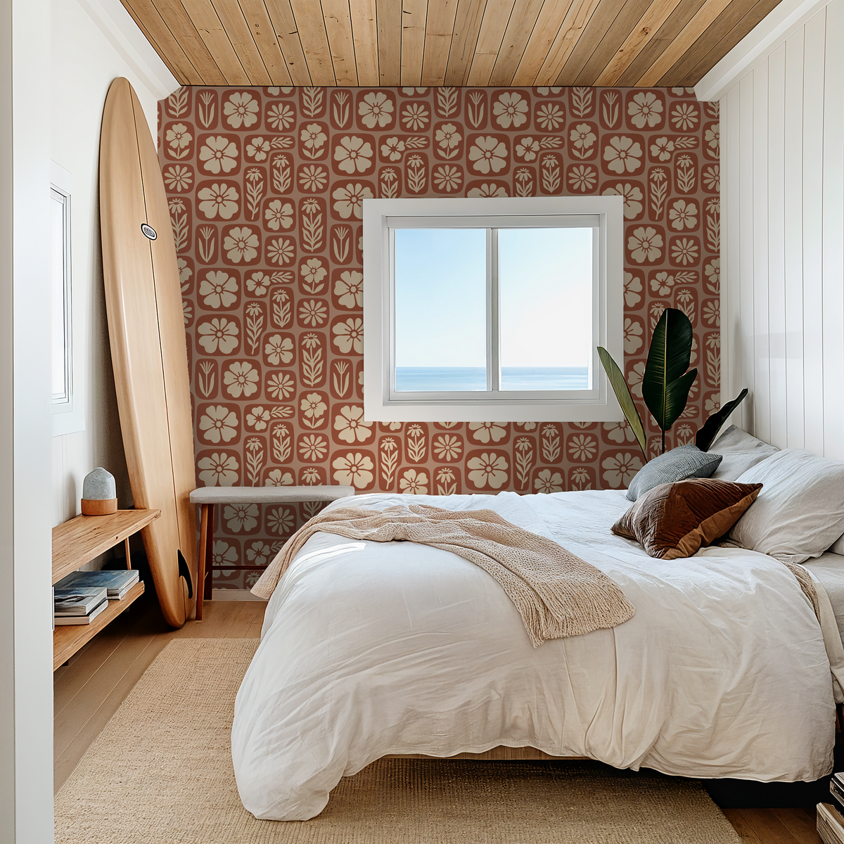 Rust floral wallpaper in cozy bedroom with surfboard and ocean view.