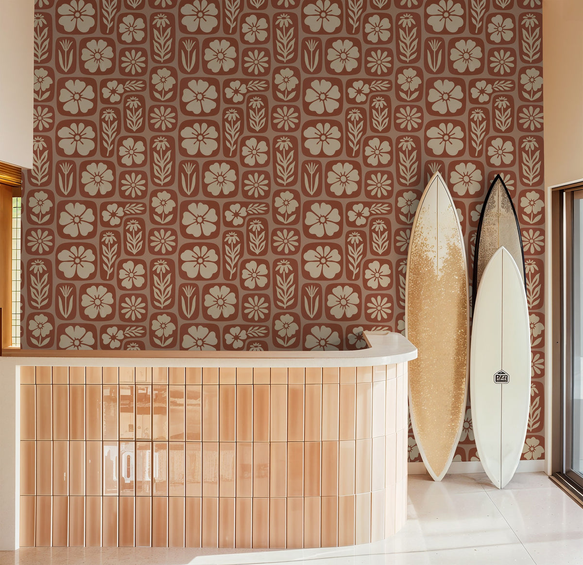 Rust terracotta floral wallpaper in modern room with surfboards and curved counter.