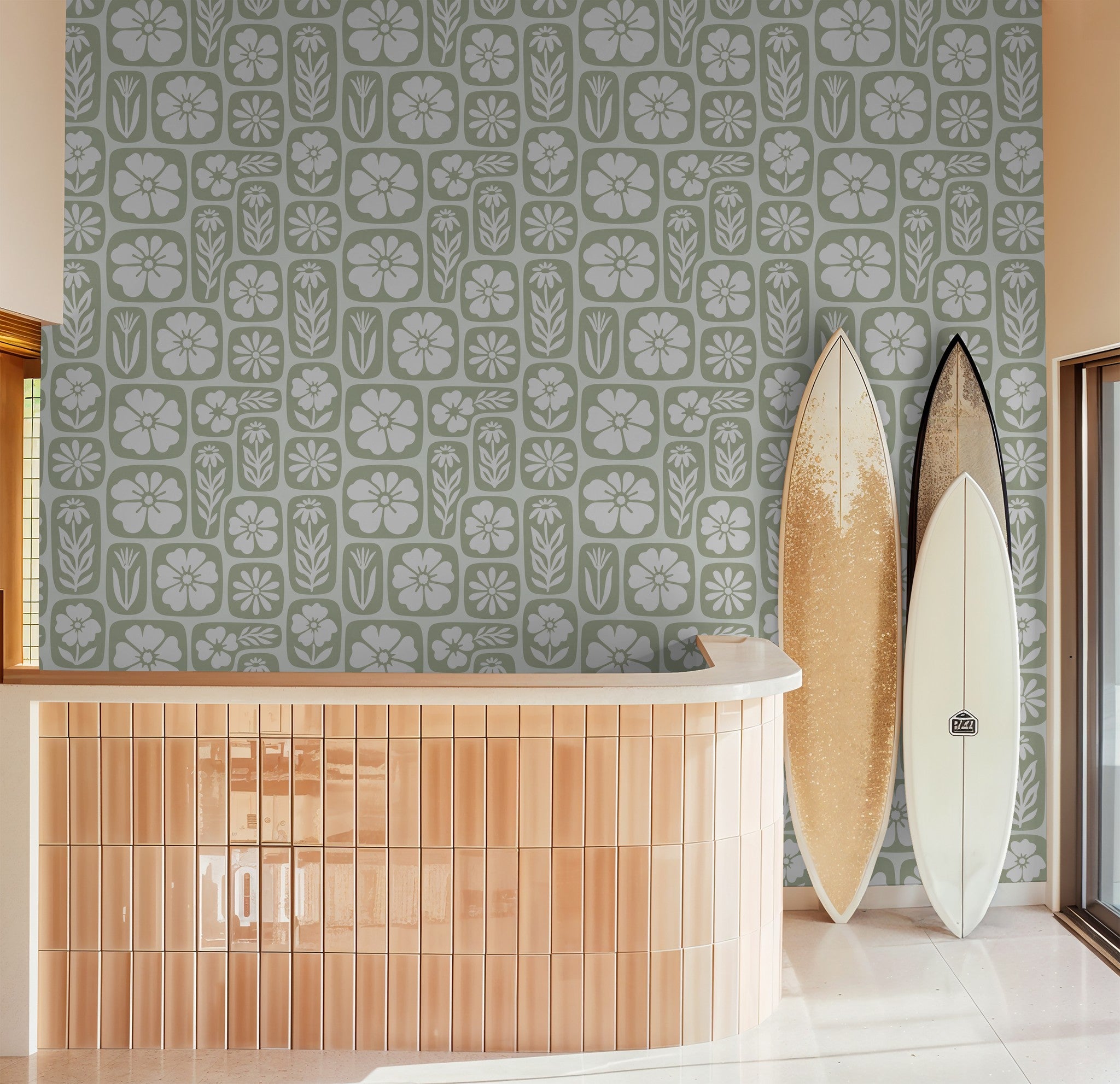 Sage green floral wallpaper in modern room with surfboards and tiled counter.
