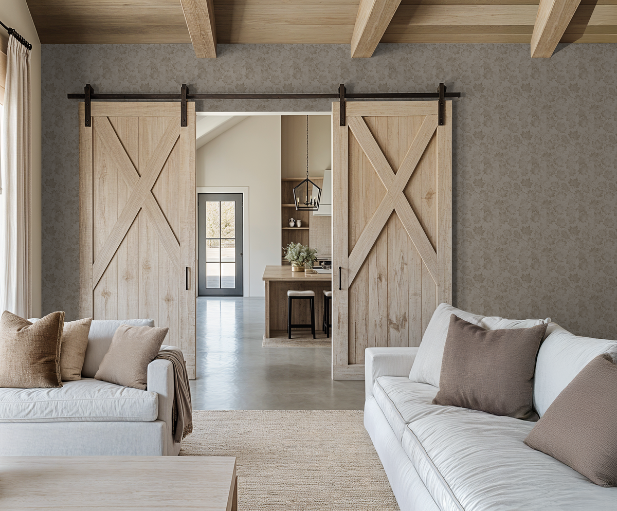 Sepia-toned leaf wallpaper in rustic living room with wooden barn doors.