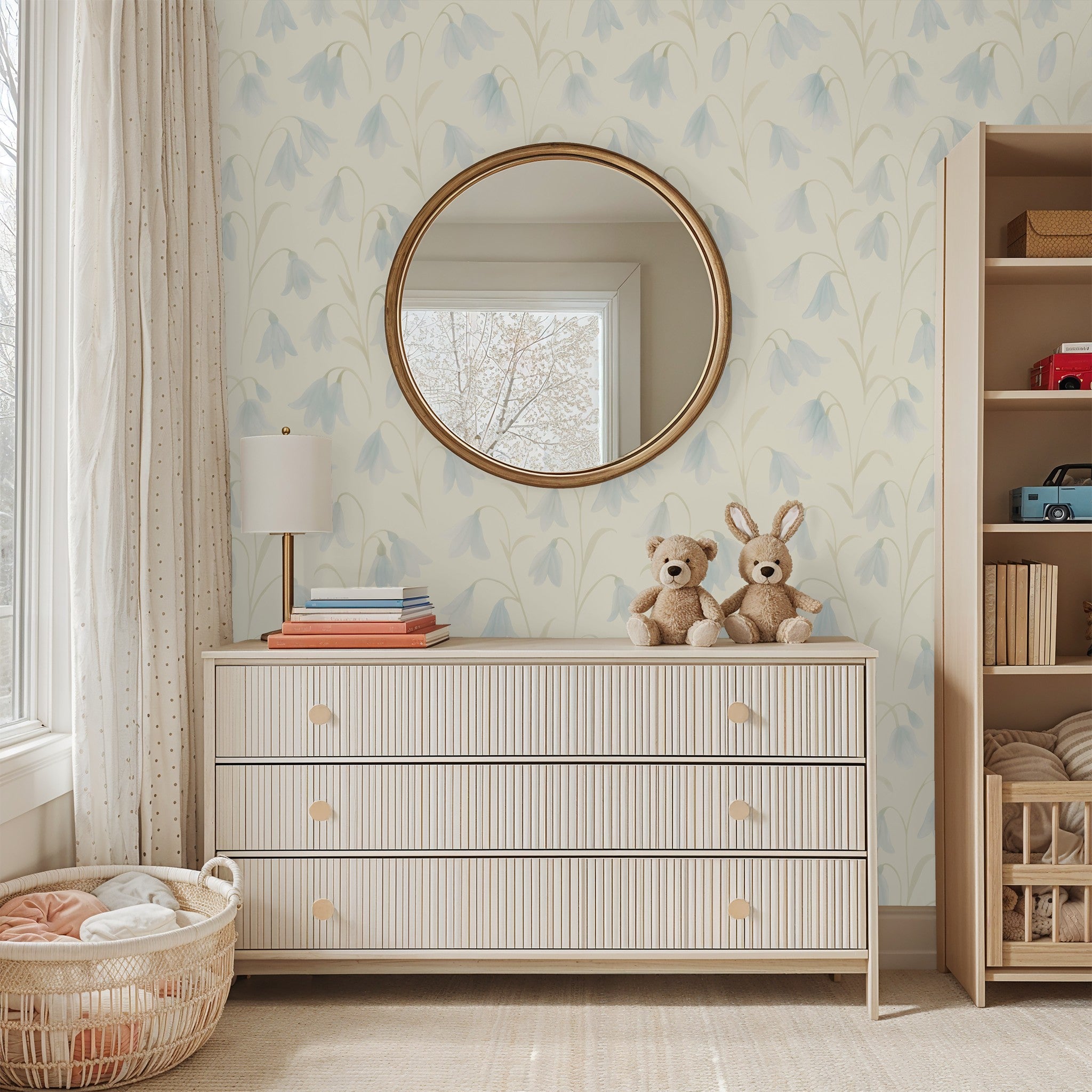 Soft blue floral wallpaper in a cozy nursery with light wood furniture.