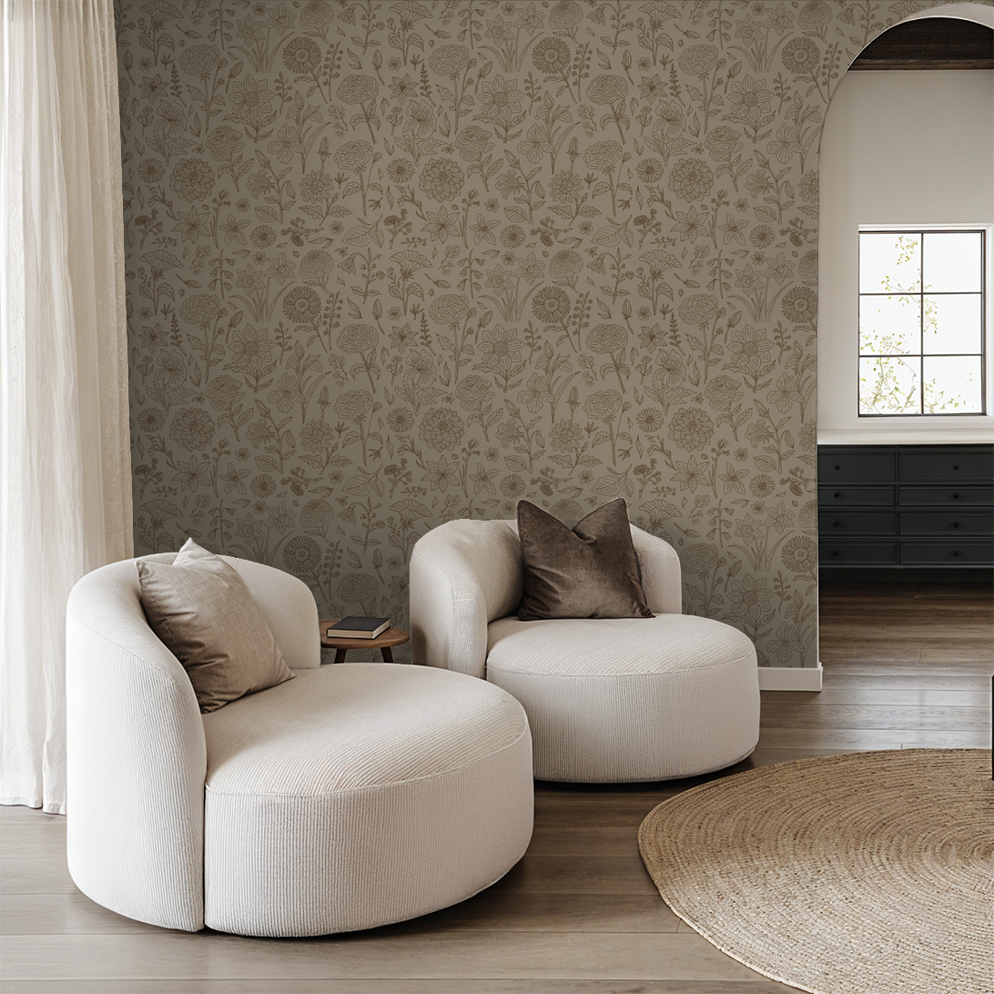 Tan floral wallpaper with botanical pattern in cozy living room with white chairs.