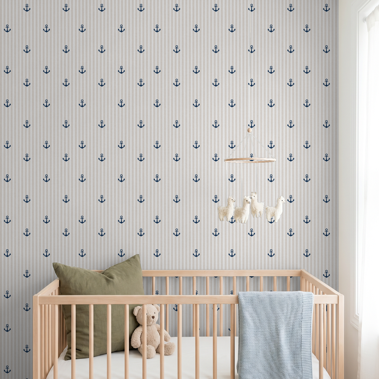 Tan and white striped wallpaper with navy anchors in a nursery setting.