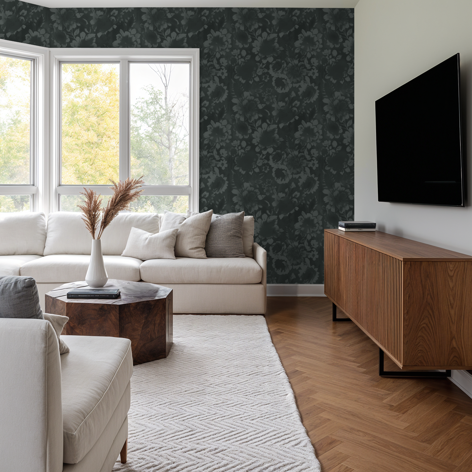 Living room with teal floral wallpaper, white sofa, and wooden furniture.