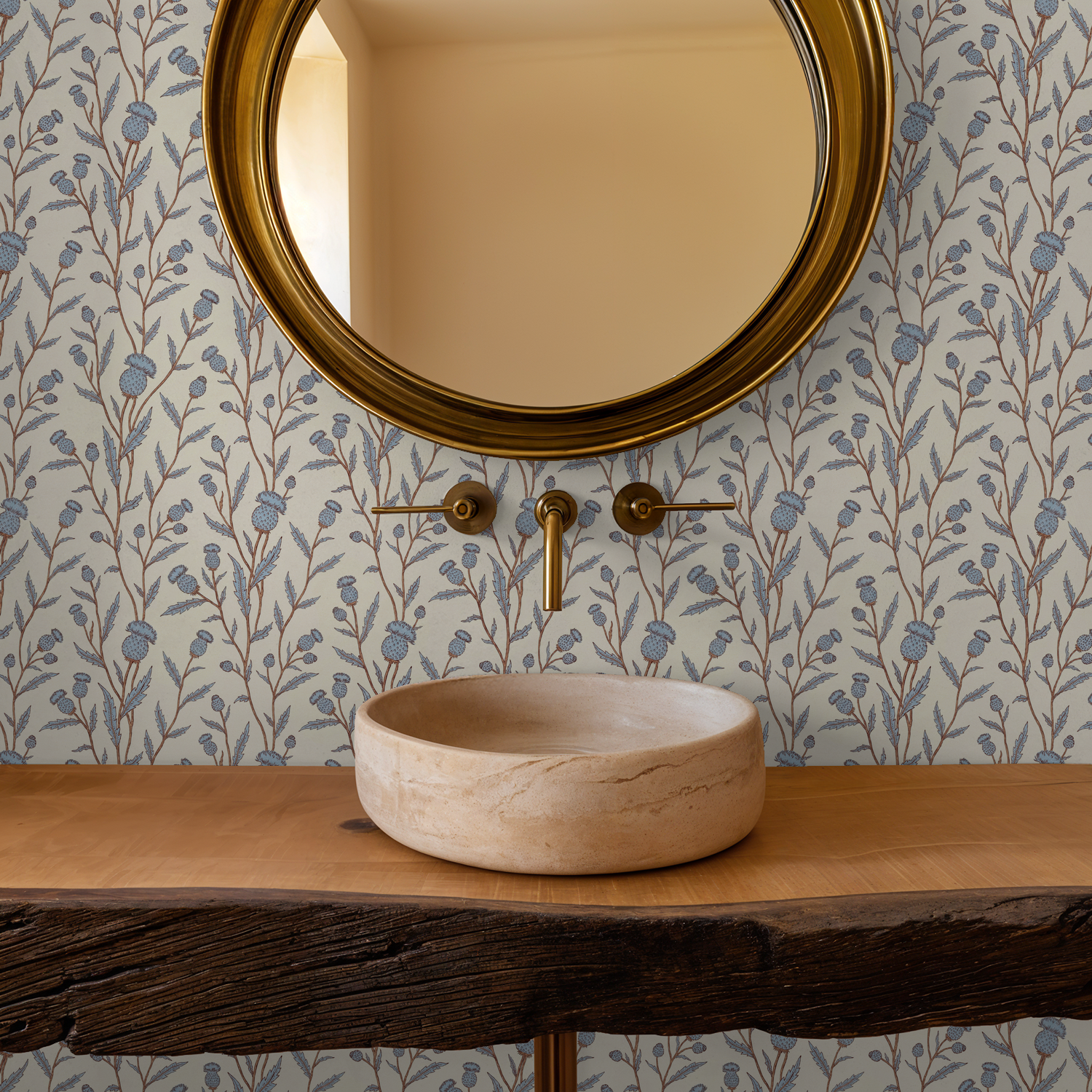 Thistle motif wallpaper in blue and brown in rustic bathroom with round mirror.