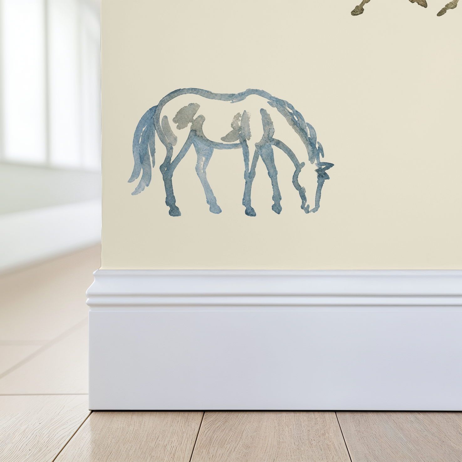 Whimsical watercolor horses on creamy wallpaper in a bright room.