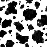 Alt text: "Greta Wallpaper by Wall Blush in stylish modern living room, showcasing bold black and white cow print design."