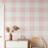 Wall Blush's Annabelle Wallpaper in stylish pink plaid adorning a modern bedroom wall, showcasing elegance and simplicity.
