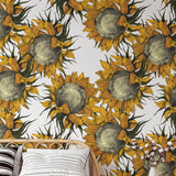 Arie Wallpaper from The Chelsea DeBoer Line in a cozy bedroom, highlighting vibrant sunflower pattern.
