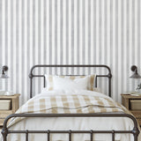 Gabbandra Stripes Wallpaper by The 7th Haven in a cozy bedroom, highlighting the elegant wall design.
