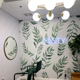 Fresh Start Wallpaper from The Minty Line enhancing a modern office room with elegant green leaf patterns.
