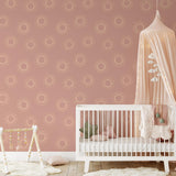 "Wall Blush's Sun Kissed Wallpaper featured in a cozy nursery room, with a focus on the wall design."