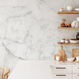 "Wall Blush Petra Wallpaper in a modern kitchen, featuring elegant marble design with open shelving and kitchenware."