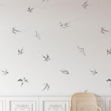 "Of a Feather (White) Wallpaper by Wall Blush installed in an elegant living room, featuring bird illustrations."