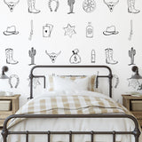 Outlaw (Black) Wallpaper by Wall Blush SG02 in a cozy bedroom, with stylish western motif designs.
