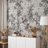 "Daphne Wallpaper by Wall Blush showcasing floral elegance in domestic living room setting, with intricate monochrome botanical patterns."