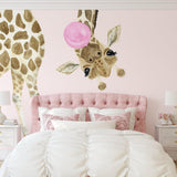 Wall Blush's Stevie Kate Wallpaper in a stylish bedroom, featuring whimsical giraffe designs with a pink backdrop.
