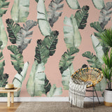 "Haleiwa Wallpaper by Wall Blush in stylish living room, showcasing large tropical leaf design."