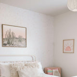 Earthy Terrazzo Wallpaper by The Minty Line in a cozy bedroom with white and pink decor.
