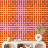 Jackie Wallpaper by Wall Blush SG02 in a modern living room, bold red and orange geometric pattern focus.
