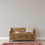 "Wall Blush's Sand Dollar Wallpaper in a cozy living room featuring a wooden bench and oriental rug."