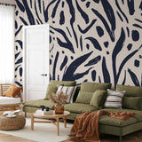 "Wall Blush Signe Wallpaper featured in stylish living room with green sofa and modern decor."